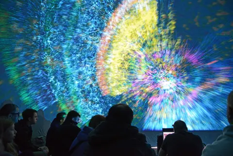 Lichtshow im Deep Space des Ars Electronica Center in Linz, Publikum davor