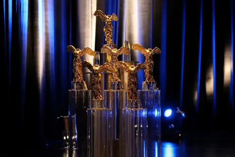 Die goldene Statue Golden Nica des Prix Ars Electronica auf der Bühne