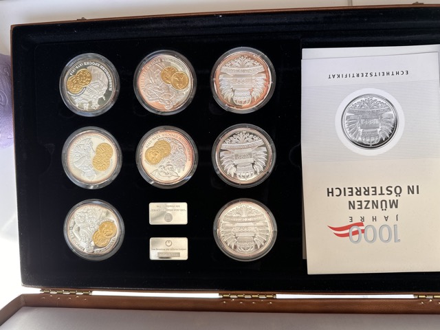 Geöffnete Kassette „1000 Jahre Münzen in Österreich“ mit 12 teilvergoldeten Silbermedaillen, 2 Silberbarren und Echtheitszertifikat